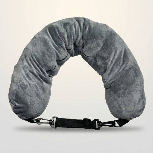 Gray neck pillow with a black strap on a light beige background